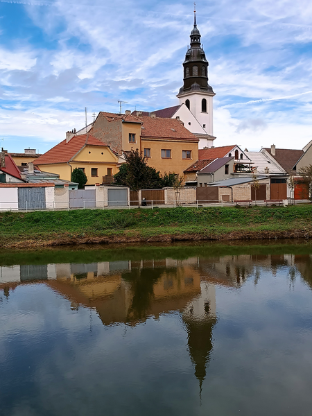 Zrcadlení kostela na hladině řeky 